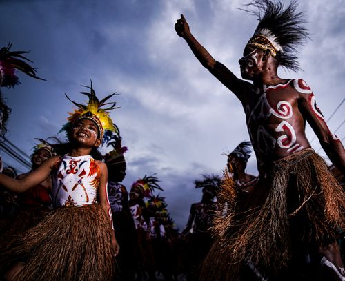 Free Energetic dancers in traditional attire celebrate under evening sky, reflecting cultural heritage. Stock Photo