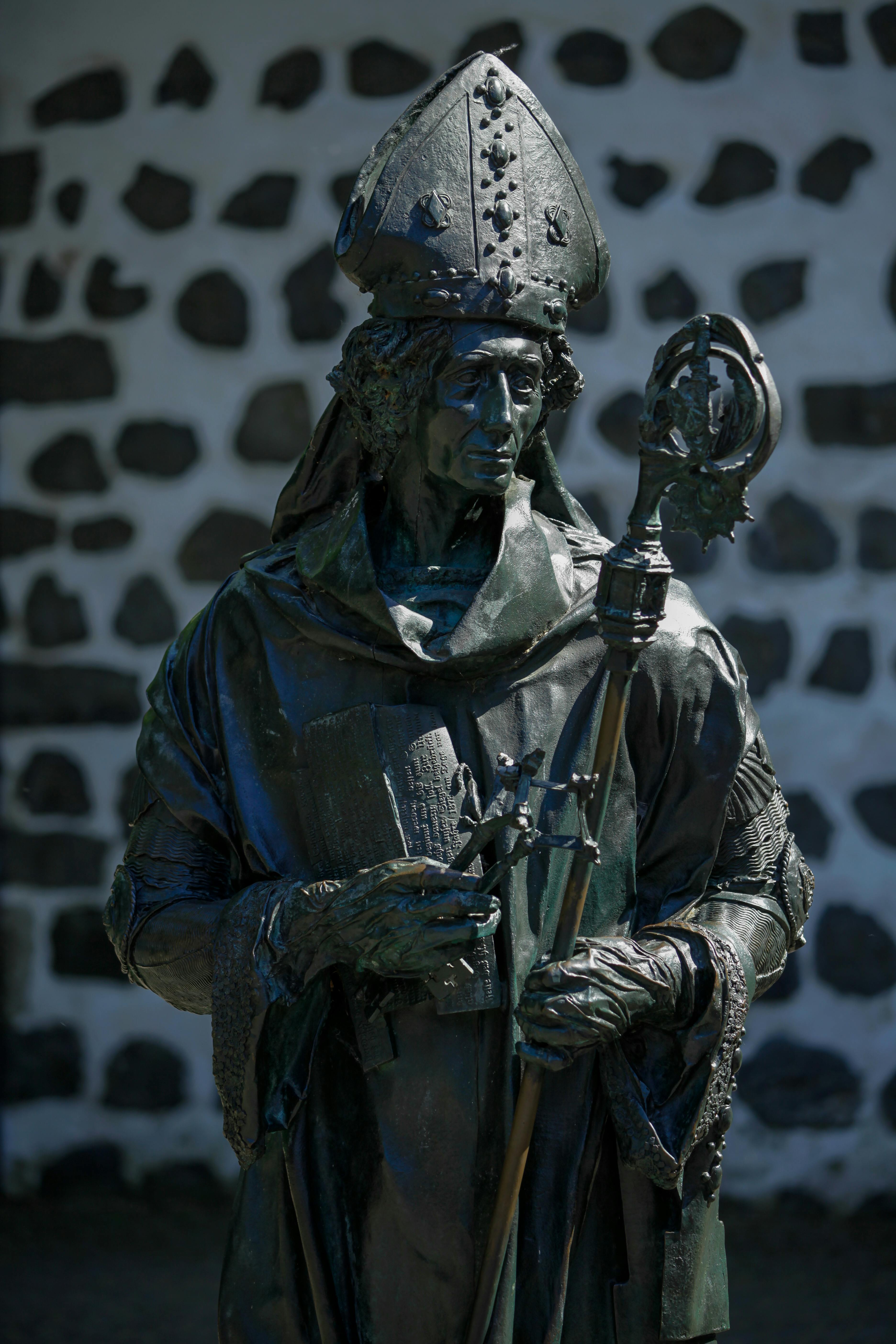 Detailed sculpture of a religious figure against a stone wall.