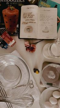 Warm kitchen scene with a vintage recipe book and baking essentials set up for a homely baking day.