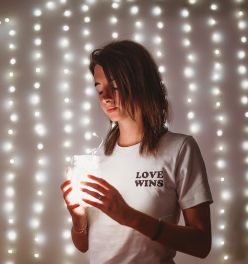 Woman Wearing White Crew-neck Shirt Holding Lamp