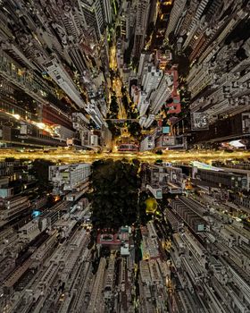 A dramatic aerial view of a city's towering skyscrapers lit up at night.