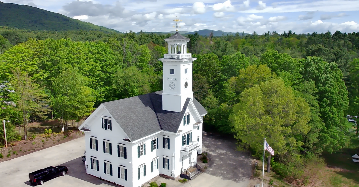 Stunning aerial capture of Effingham Town Hall, New Hampshire, surrounded by lush greenery.