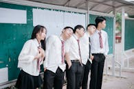 Group of Students in School Uniforms Relaxing Outdoors