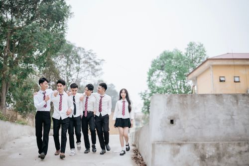 Free Group of students in uniforms walking together outside on a bright day. Stock Photo