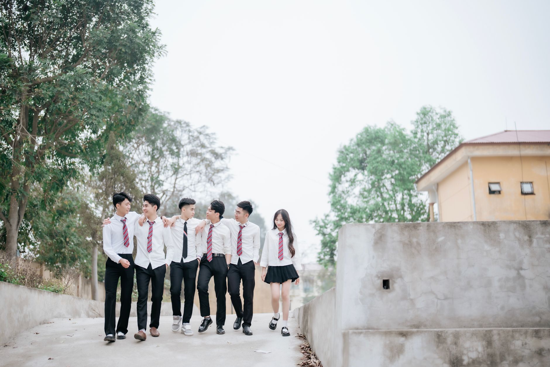 students in uniforms walking through a historic school hallway