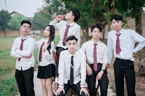 Free A group of young students wearing uniforms poses casually in an outdoor setting. Stock Photo