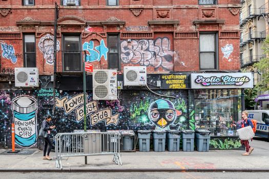 Colorful graffiti and urban scene on a street in the Lower East Side, NYC, showcasing vibrant street art.