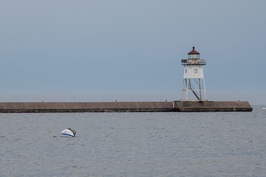 Serene view of Grand Marais lighthouse on Lake Superior during a calm day.