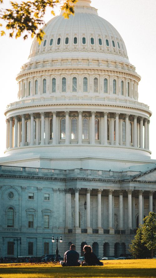 Free A couple enjoys a sunny day on the lawn in front of the iconic US Capitol in Washington, DC. Stock Photo