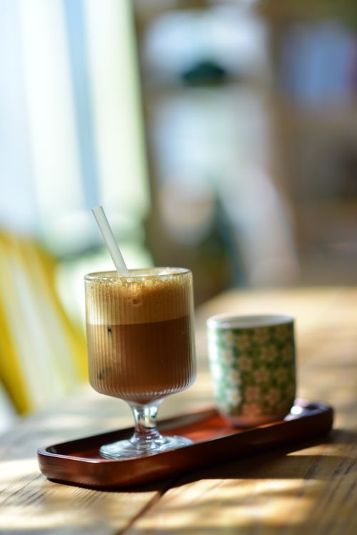 Free Aesthetic shot of iced coffee and cup on a tray, capturing sunny café vibes. Stock Photo