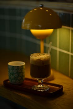 A warm, inviting coffee shop scene with a glass of iced coffee under soft, ambient lighting.