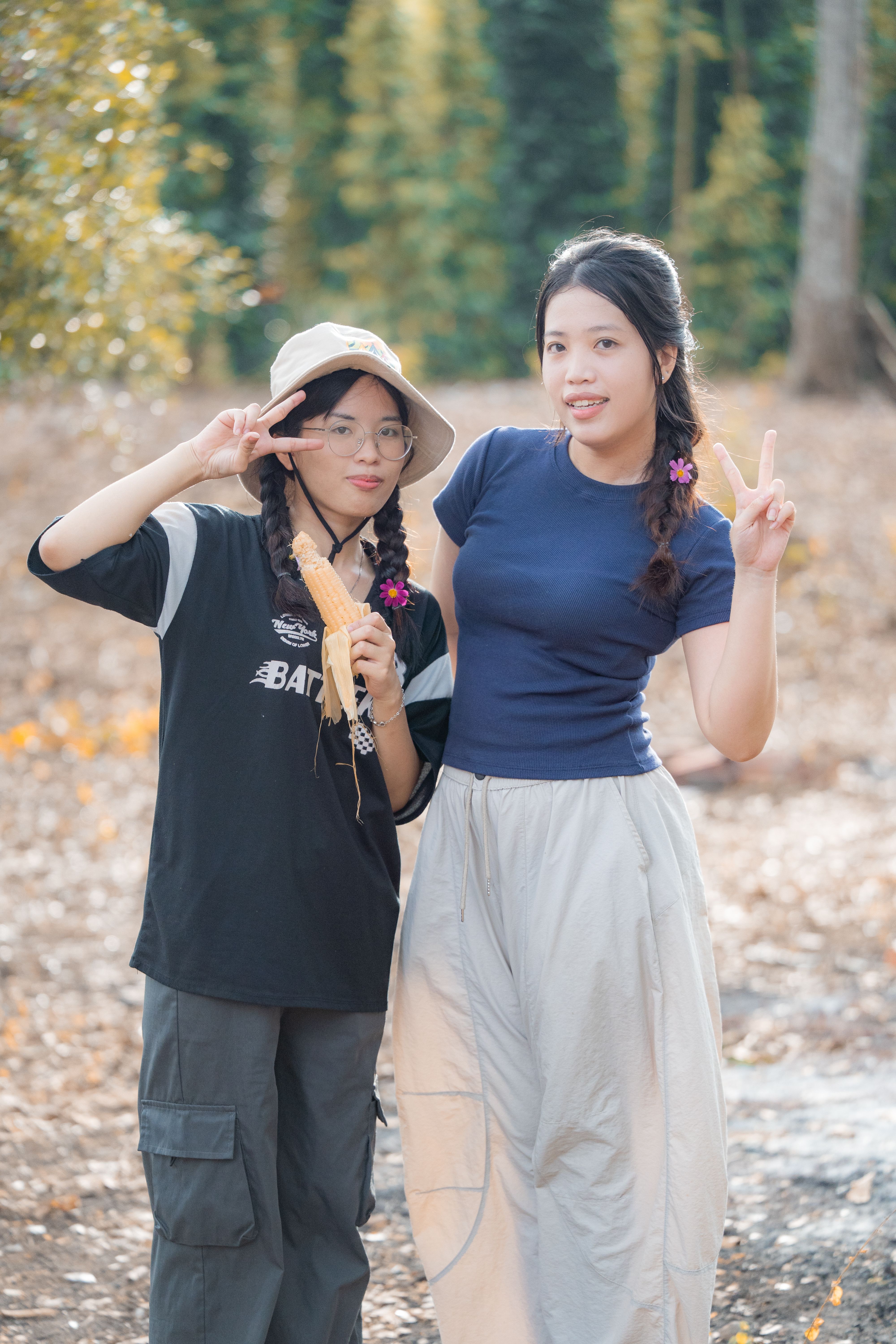 Two Young Women Posing Outdoors in Casual Attire · Free Stock Photo