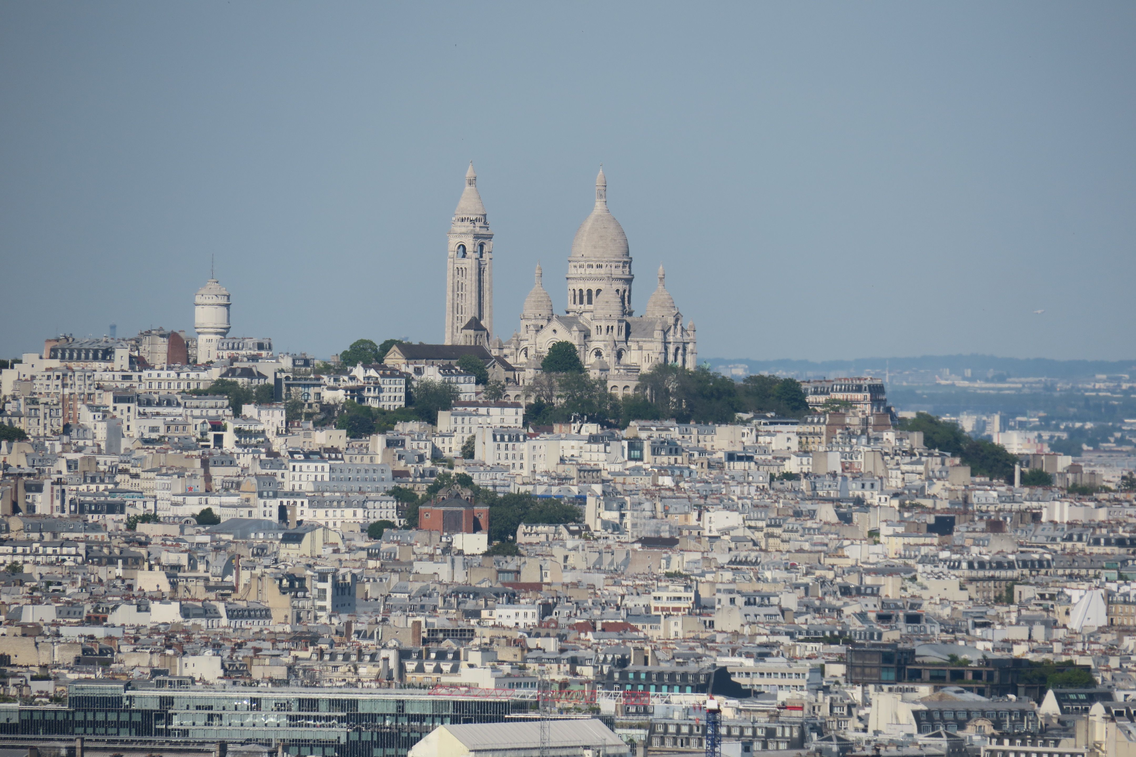 Aerial view of Paris featuring the iconic Sacré-Cœur Basilica under clear blue skies. Aerial view of Paris featuring the iconic Sacré-Cœur Basilica under clear blue skies.