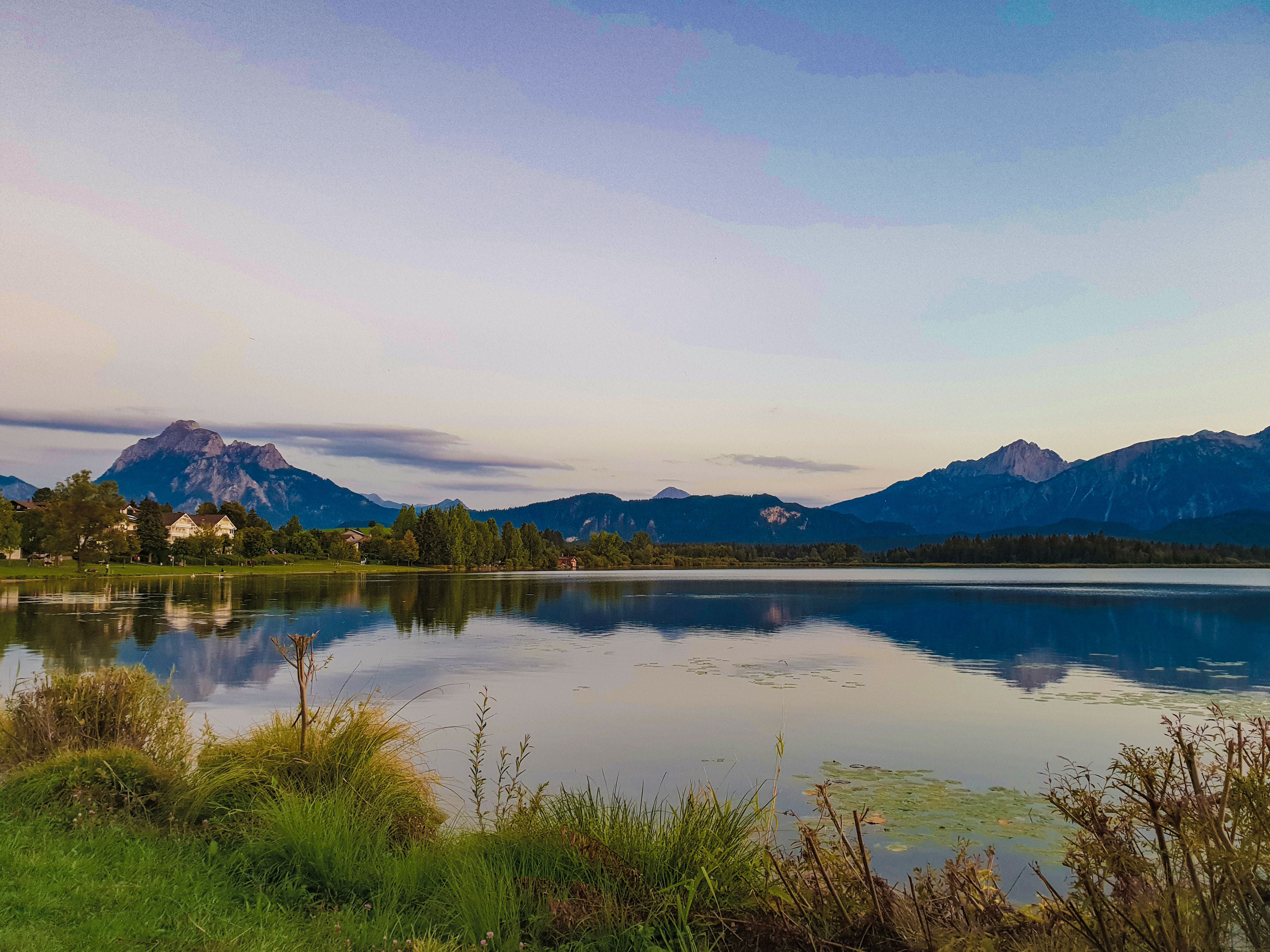 Stunning view of a serene lake reflecting the Bavarian Alps at twilight.