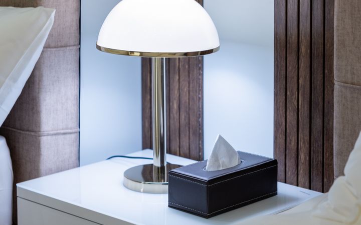 Modern hotel room in Dubai featuring a stylish nightstand lamp and luxurious decor.
