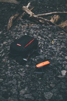 Close-up of an orange drone with camera bag on rocky terrain, perfect for outdoor photography themes.