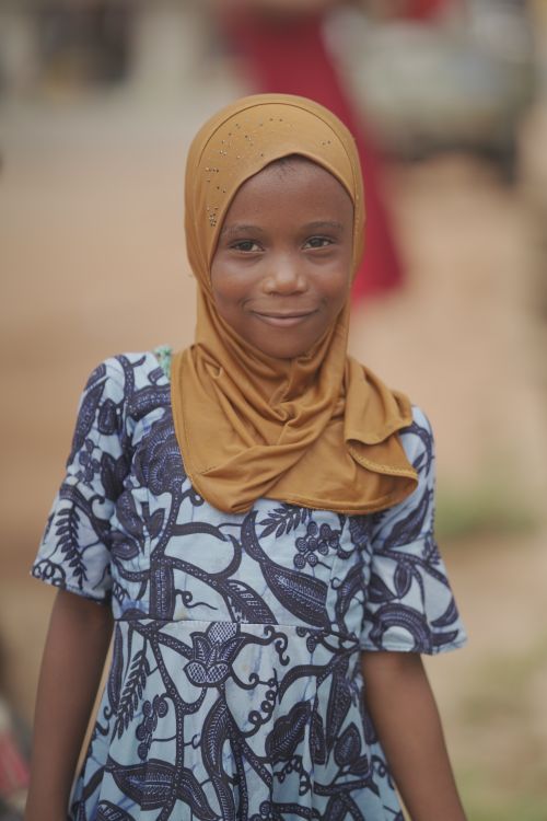 Free Charming portrait of a young girl wearing a hijab, smiling warmly outdoors in Ghana. Stock Photo