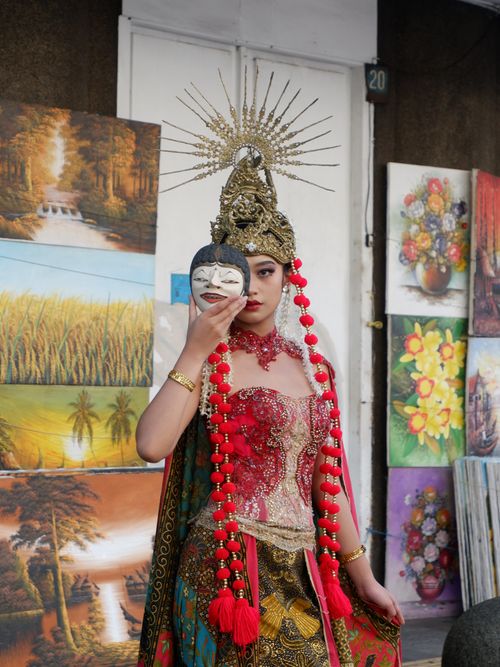 Free A traditional dancer poses with a cultural mask, showcasing elaborate attire in vibrant surroundings. Stock Photo