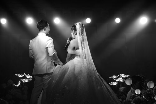 Free A bride and groom sharing a moment on stage during a wedding ceremony. Stock Photo