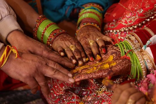 Close-up of traditional Indian wedding rituals with colorful attire and intricate henna designs.