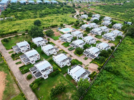 Aerial view of a modern residential neighborhood with white houses and green lawns.