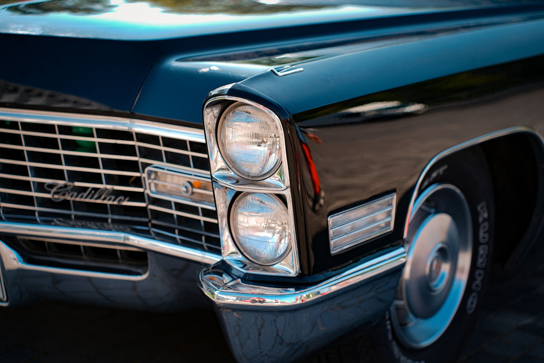 Close-up of a vintage Cadillac car highlighting the chrome details and headlights.