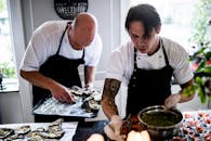 两位厨师在餐厅厨房里用新鲜的食材，专注地准备着美食