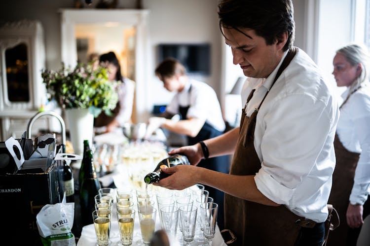 Man Pouring Wine On Glasses