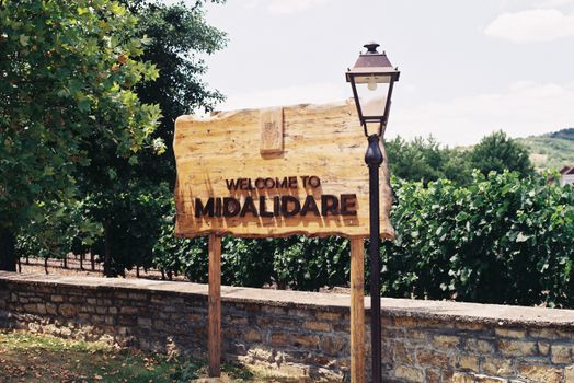 Welcome sign at Midalidare Vineyard with lush greenery background.