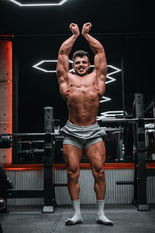 Free Fit adult male posing in a gym, showcasing muscular physique and confidence. Stock Photo
