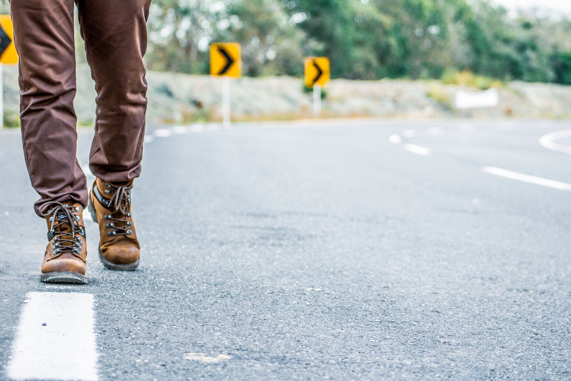 Close-up of a person walking on a rural road in Colombia, showcasing footwear and travel theme.