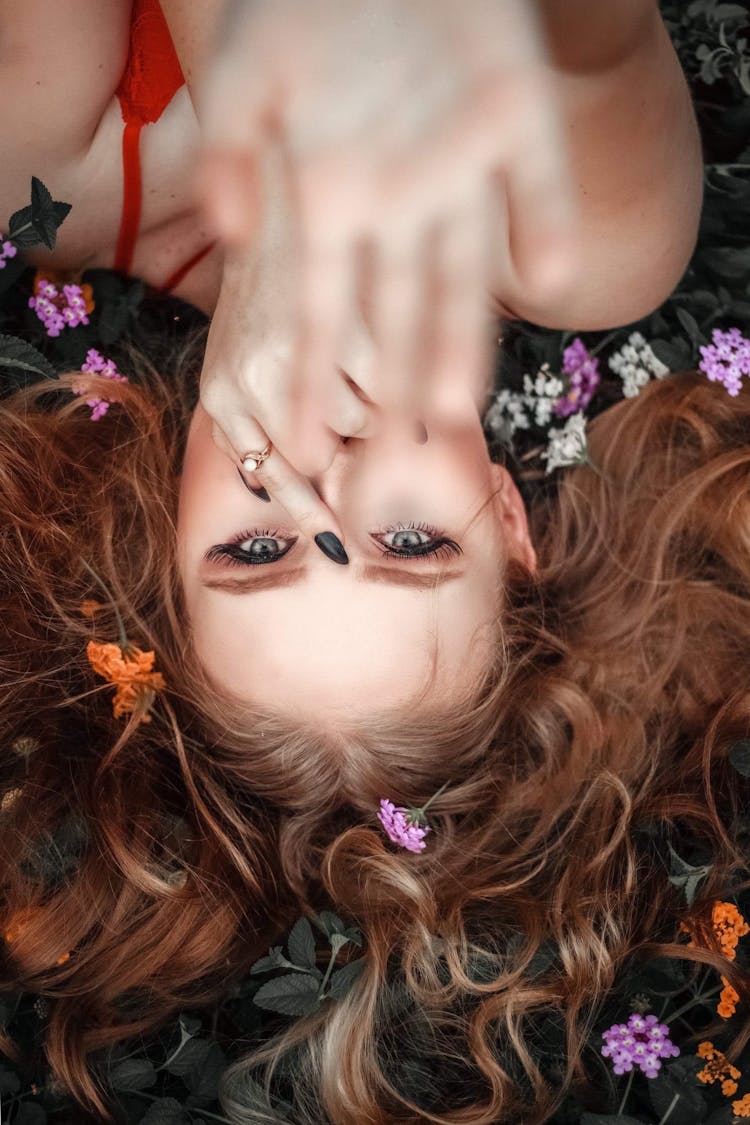 Woman Lying Down On Flowers And Leaves