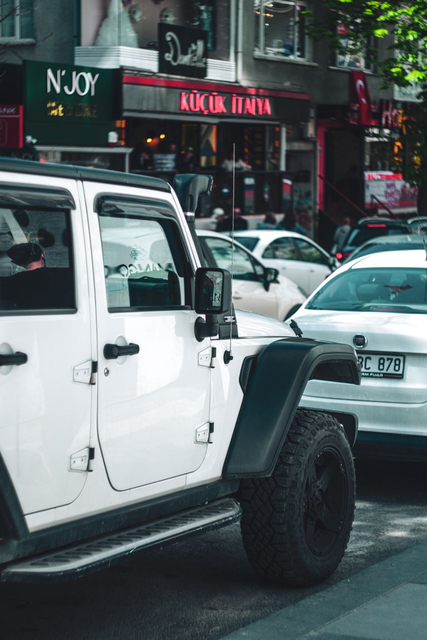 A white SUV on a busy city street.