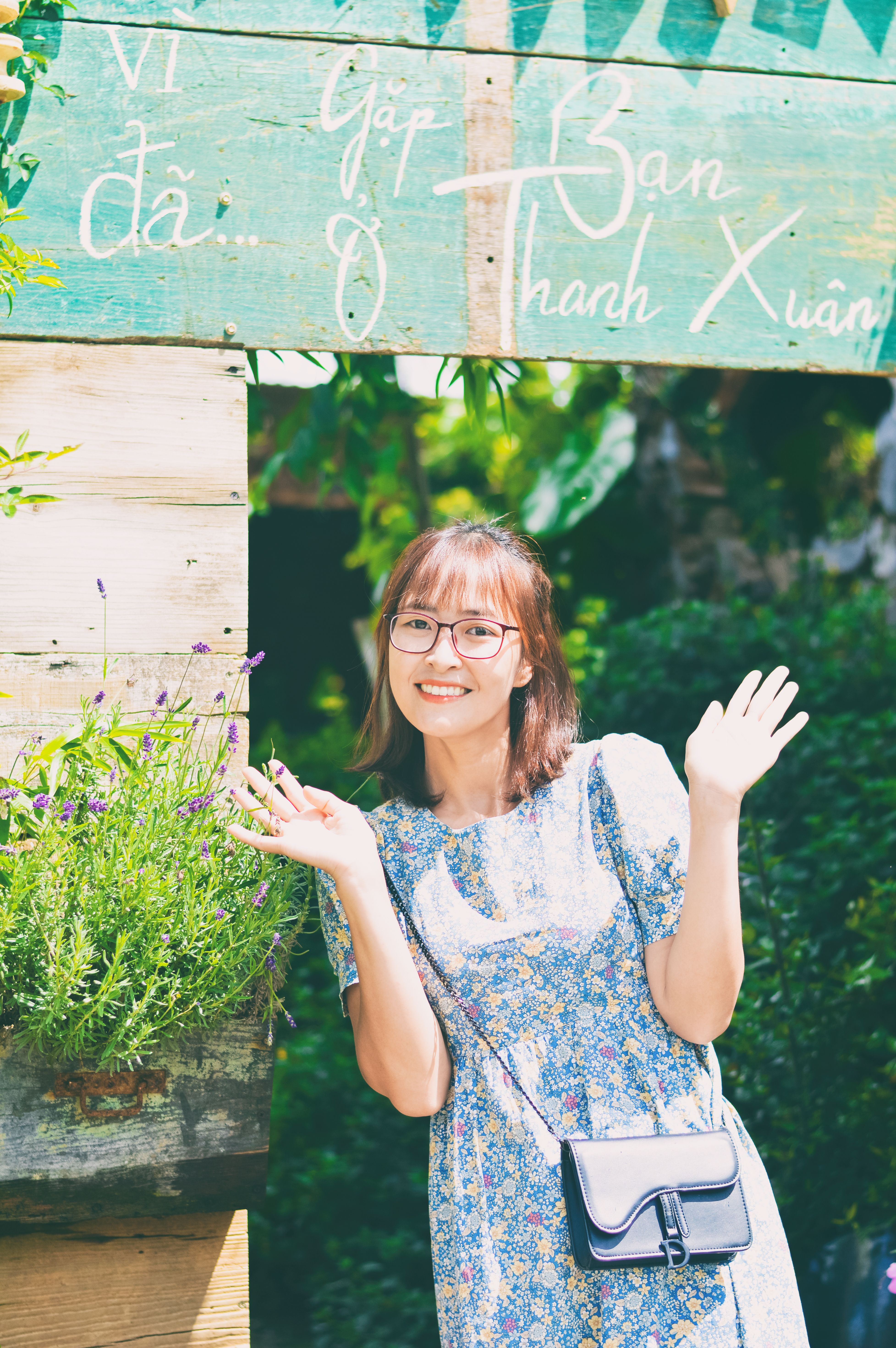 Smiling Woman Posing Outdoors with Sign · Free Stock Photo