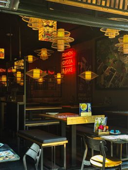 Interior of an Asian restaurant with neon lights, wooden decor, and vibrant ambiance.