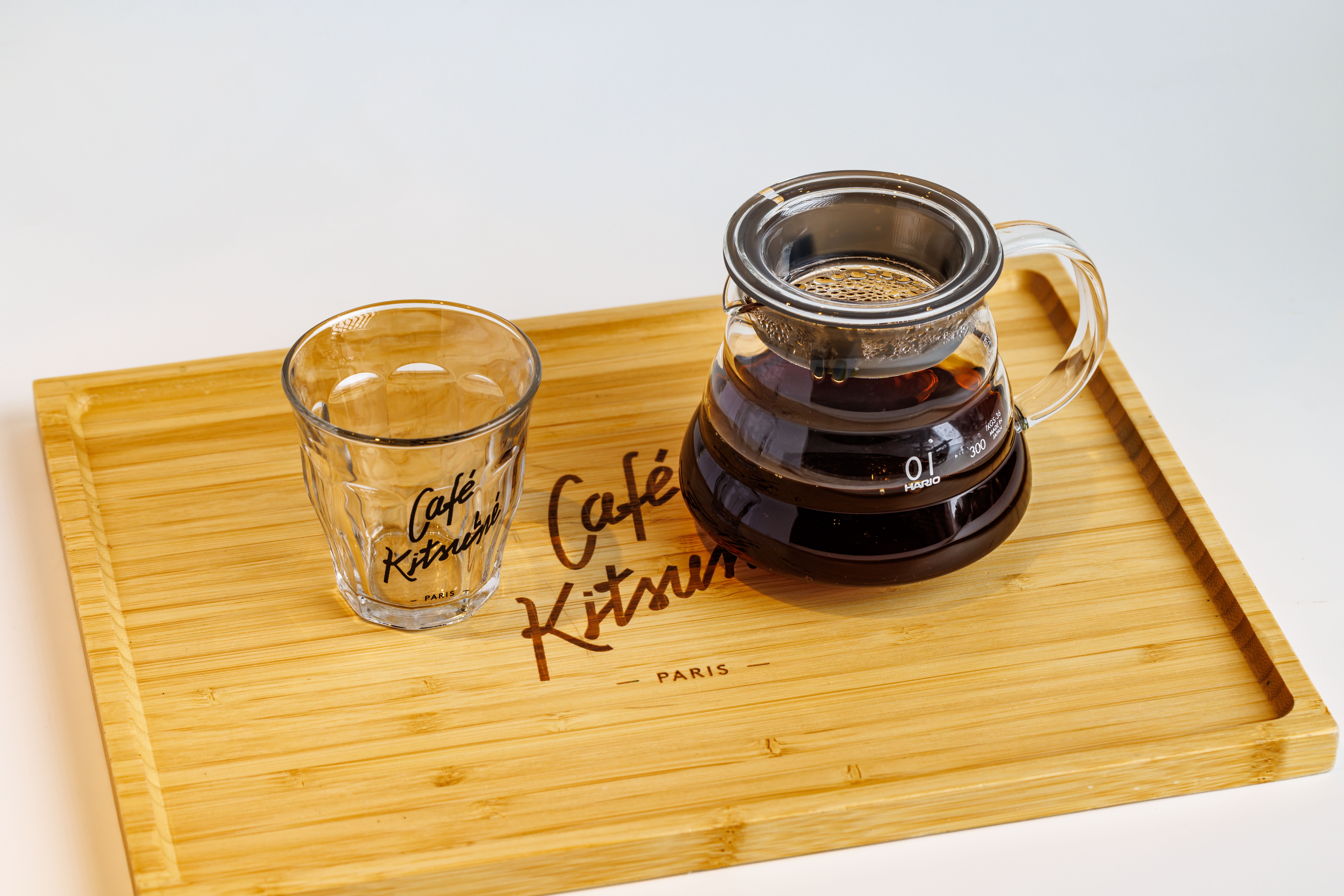 Gratis Set da caffè minimalista con tazza di vetro e versamento su vassoio di bambù. Foto a disposizione