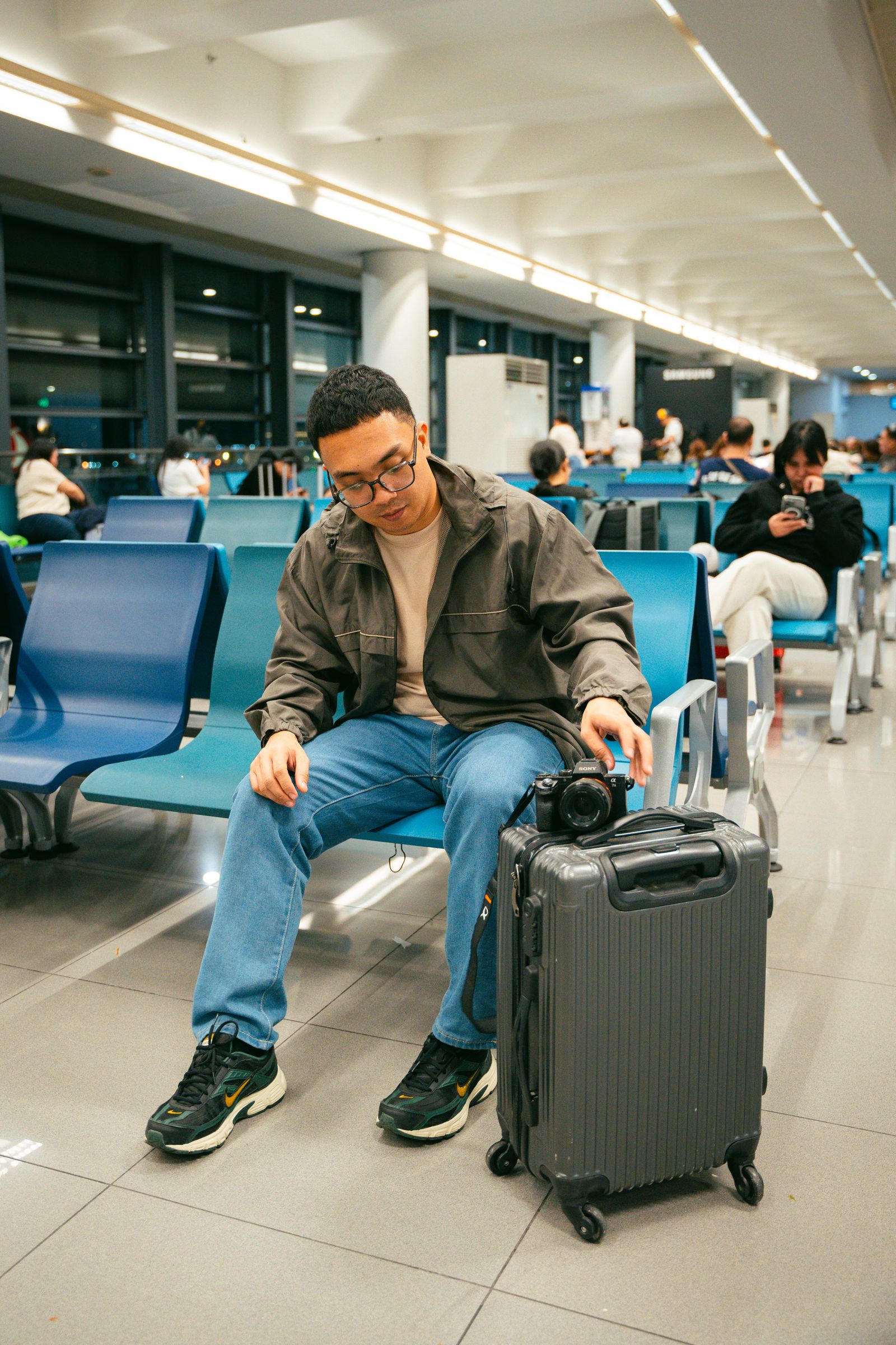 Traveler seated in an airport terminal beside luggage