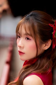 Side profile of a woman in elegant traditional dress with flower in hair, evoking cultural beauty.