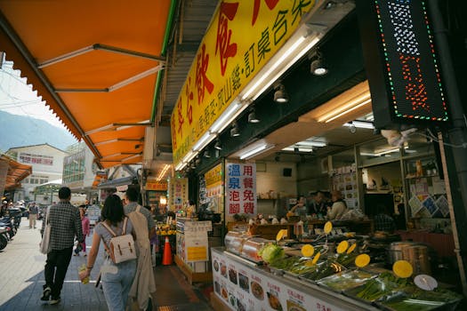 Vibrant Asian street market scene with various food stalls and a crowd of people exploring.