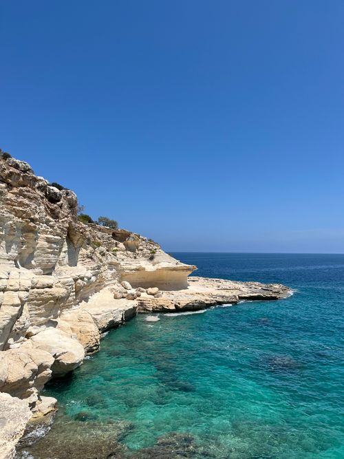 Free Beautiful coastal cliffs against a clear blue sky with turquoise ocean waters. Stock Photo