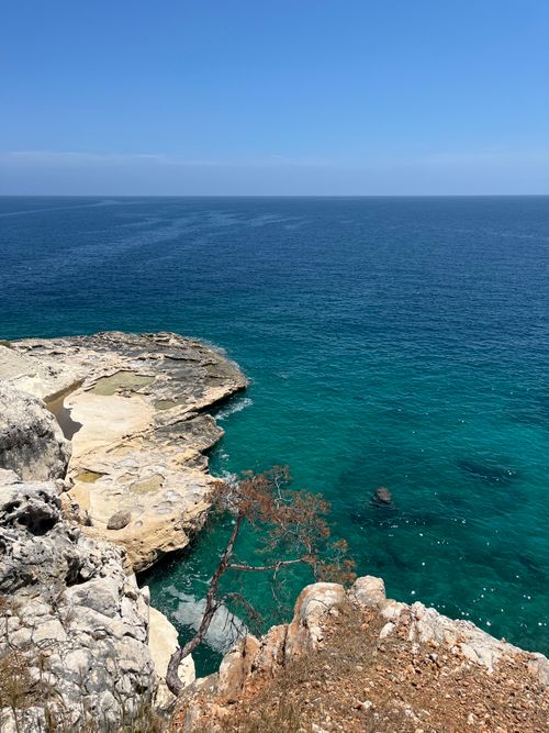 Free Breathtaking coastal landscape showcasing vibrant blue seas and rocky cliffs under a clear sky. Stock Photo