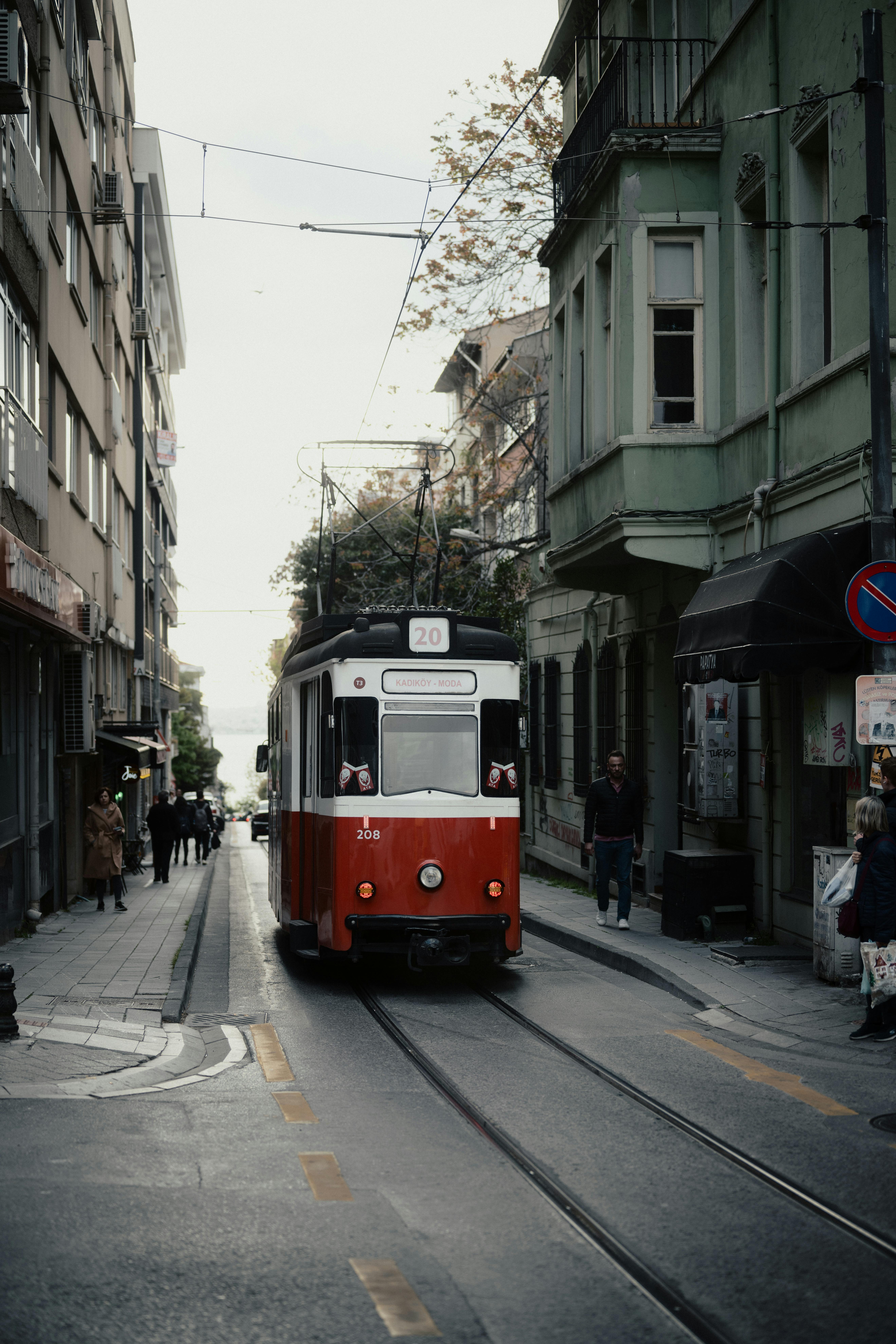 bezplatná Stará červená tramvaj na úzké městské ulici v Istanbulu, zachycující klasickou dopravní scénu. Základová fotografie