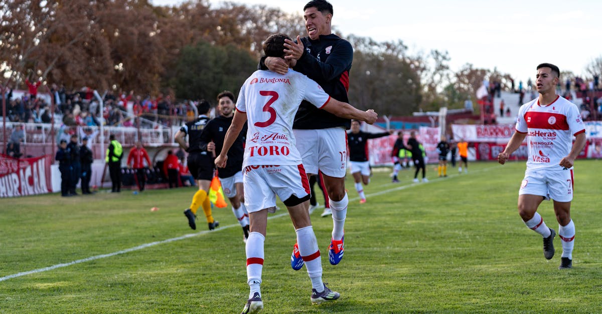 Football players celebrating a victory during a match, surrounded by enthusiastic fans.