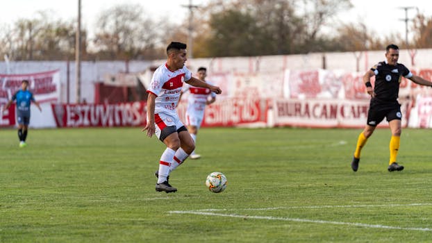 Dynamic action shot capturing football players during a match on a grassy field, showcasing agility and teamwork.