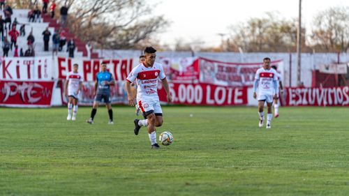 Free A soccer player in red and white uniform dribbles during a daytime outdoor match. Stock Photo