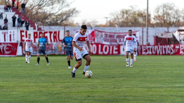 Dynamic scene of a soccer player in action during a match on a grass field.