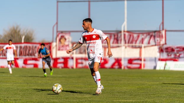 Focused football player in action during a match on a sunny day.