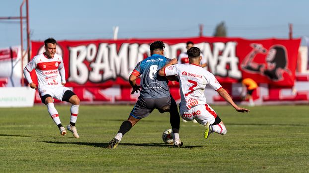 Exciting soccer game moment with players in action on a sunny day outdoors.