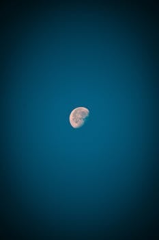 A detailed image of the moon illuminated against a deep blue night sky, taken in León, Mexico.