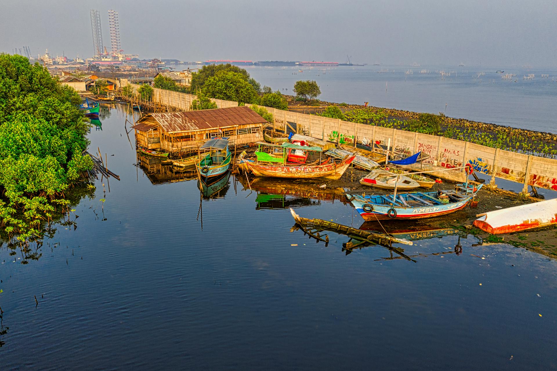 Colorful fishing boats docked in Jakarta harbor at daytime, reflecting local maritime culture.